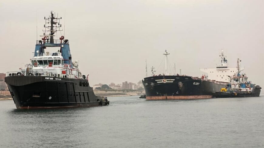 A tugboat pulls the Marshall Islands-flagged bulk carrier M/V Glory in the Suez Canal after it was refloated