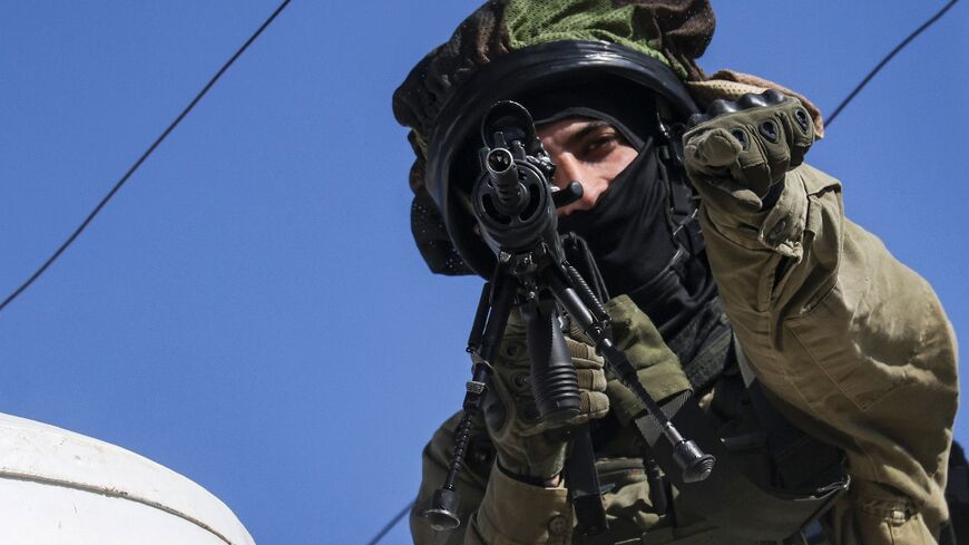 An Israeli soldier points his finger in the village of Halhul in the occupied West Bank, where Hamdi Abu Dayyeh was shot dead on Tuesday