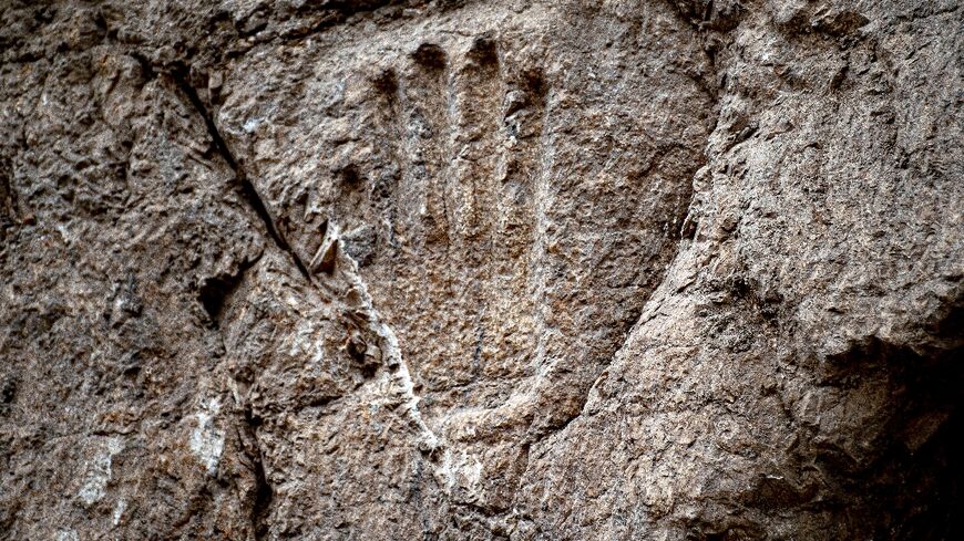 Israeli archaeologists are trying to uncover the meaning of a recently discovered hand imprint carved into the stone wall of an ancient moat outside Jerusalem's Old City