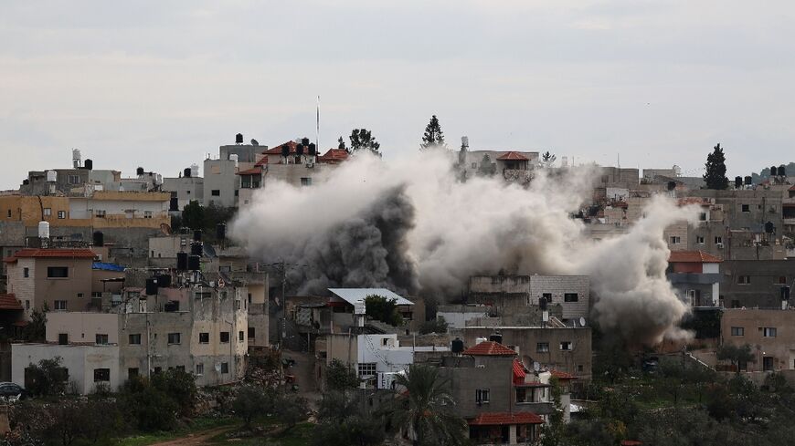 Smoke billows from a house as Israeli soldiers demolish the home of a Palestinian, accused of killing an Israeli soldier, in the village of Kafr Dan in the occupied West Bank on January 2, 2023