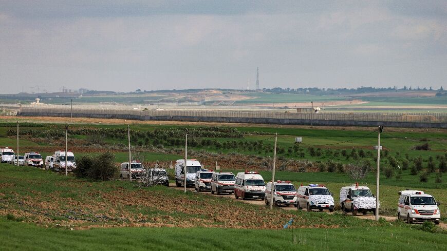 A convoy of Palestinian ambulances move along the border fence between Israel and the Gaza Strip on January 9 