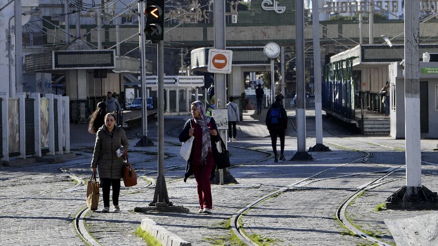 Tunisians are pictured next to a tram station in the capital Tunis during a public transport employee strike on Monday