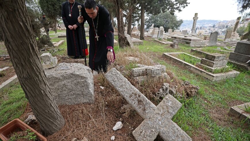 Hosam Naoum, archbishop and caretaker of the Protestant cemetery, inspects vandalised graves on Mount Zion outside Jerusalem's Old City 