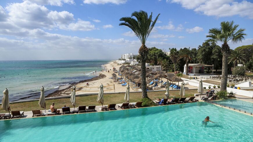 A tourist swims in a swimming pool at a hotel in Tunisia's resort town of Hammamet, about 66 kilometres south of the capital Tunis, on October 7, 2021. - The October sun warms the sands of Hammamet beach on the Tunisian coast, but the coronavirus pandemic still casts a shadow, and visitors are few on the ground. After two ruined seasons in a row, operators in Tunisia are licking their wounds and hoping the lifting of travel restrictions will spell better days. (Photo by ANIS MILI / AFP) (Photo by ANIS MILI/