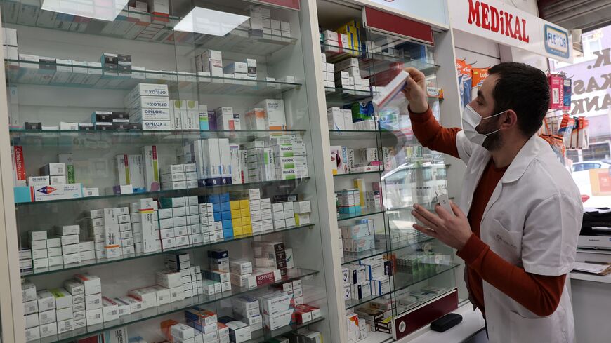 An employee takes a box of medicines on shelves at a pharmacy in the Turkish capital Ankara on December 13, 2021. - Turkeys pharmacists have brought to light the struggle of many patients who need medicines to treat diseases like diabetes and childrens fevers but cannot find them. They say the crisis that has deteriorated because of the fall in the Turkish liras value. (Photo by ADEM ALTAN/AFP via Getty Images)