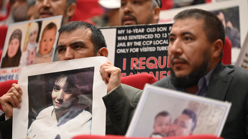 Members of Muslim Uyghur minority present pictures of their relatives detained in China during a press conference in Istanbul, on May 10, 2022. (Photo by OZAN KOSE/AFP via Getty Images)
