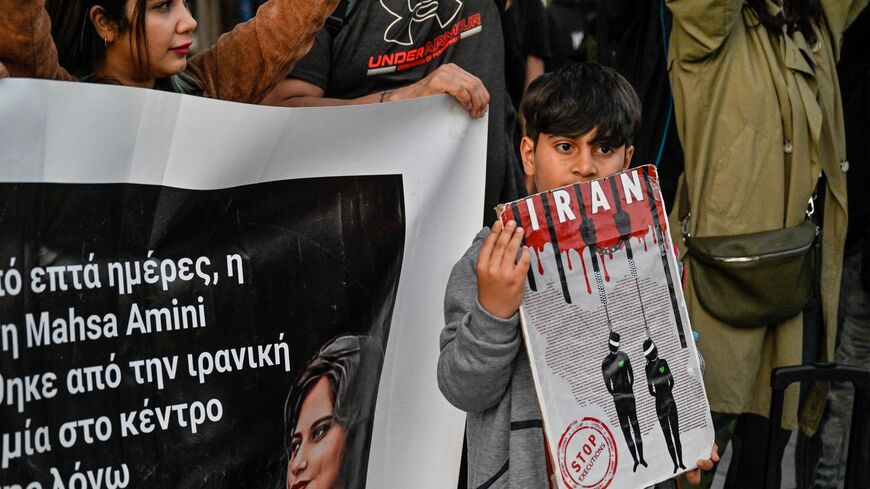Iranian refugees and Iranians living in Greece hold placards and a banner as they take part in a demonstration to commemorate 40 days from the death of Iranian Mahsa Amini while in police custody in Iran, in central Athens on October 29, 2022. (Photo by LOUISA GOULIAMAKI/AFP via Getty Images)
