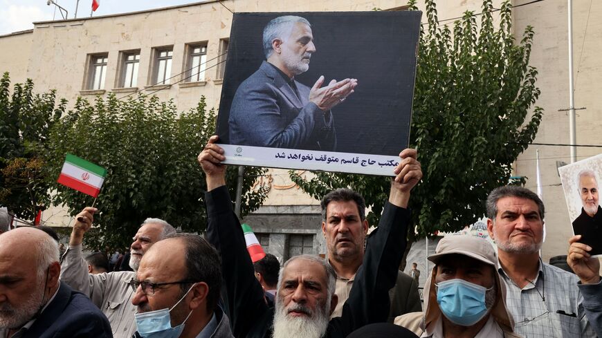 A protester holds a portrait depicting the slain top commander of the Iranian revolutionary guard corps (IRGC) Qasem Soleimani while praying, during an anti-German demonstration condemning Germany's support of Berlin-based Iranian opposition TV stations and anti-government protests in Iran, outside the German embassy headquarters in Iran's capital Tehran on November 1, 2022. (Photo by ATTA KENARE/AFP via Getty Images)