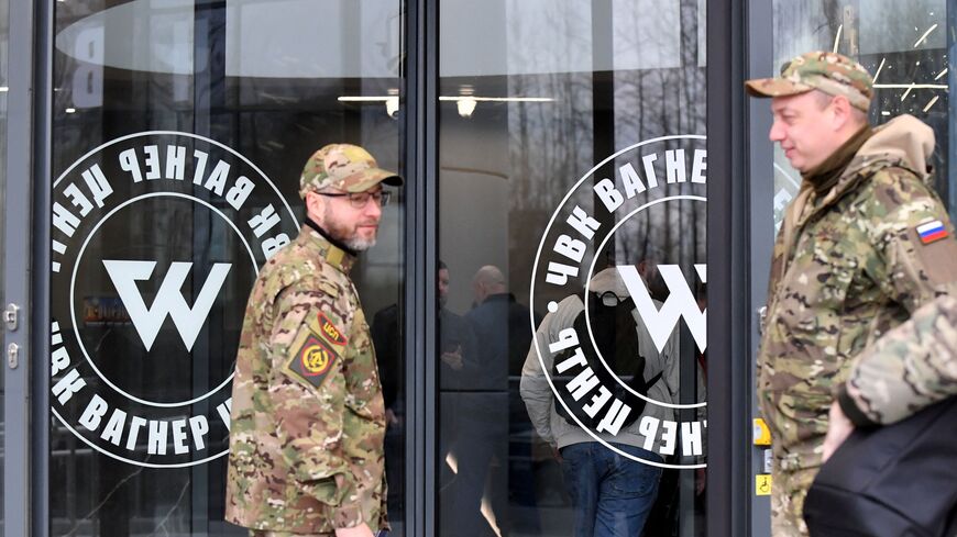 Visitors wearing military camouflage stand at the entrance of the 'PMC Wagner Centre', associated with the founder of the Wagner private military group (PMC) Yevgeny Prigozhin, during the official opening of the office block on the National Unity Day, in Saint Petersburg, on November 4, 2022. (Photo by OLGA MALTSEVA/AFP via Getty Images)