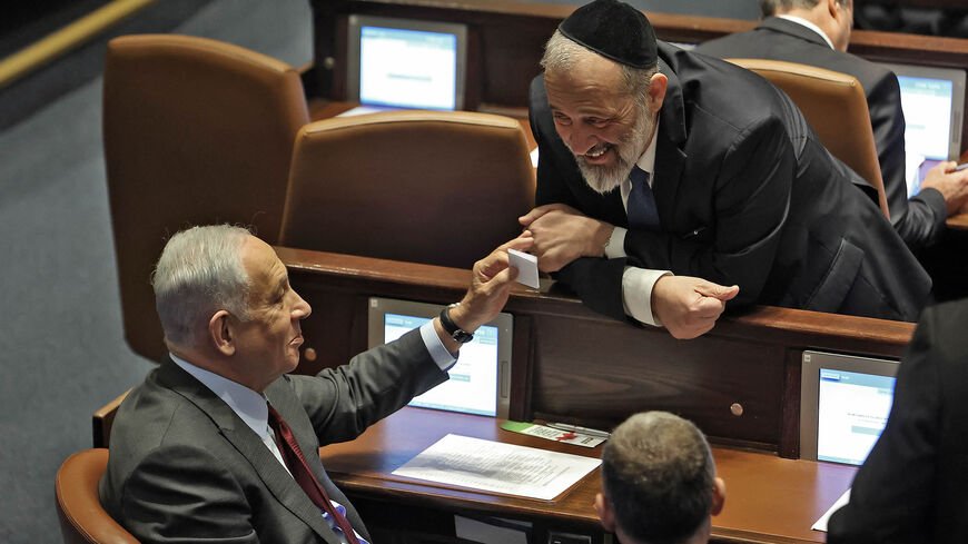Israeli Prime Minister-designate Benjamin Netanyahu speaks with Knesset member Aryeh Deri of the Shas party during a session to elect the new speaker of the assembly at its Plenum Hall, Jerusalem, Dec. 13, 2022.