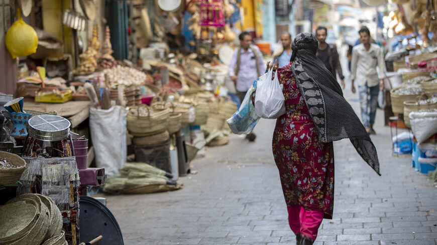 A Yemeni woman shops at a market in Yemen's third city of Taiz, on December 15, 2022. - Yemeni society, although deeply conservative, has traditionally allowed space for individual freedoms. But this is changing under the Huthi movement, which was founded with the aim of pushing for a theocracy. (Photo by AHMAD AL-BASHA/AFP via Getty Images)