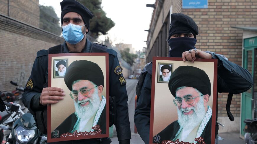Policemen gather with images of Iran's supreme leader Ayatollah Ali Khamenei during a protest against defamatory cartoons depicting him published by French satirical weekly Charlie Hebdo, outside the French embassy in Iran's capital Tehran on January 8, 2023. (Photo by ATTA KENARE/AFP via Getty Images)