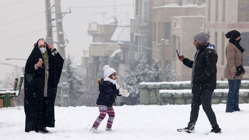 Iranians enjoy a walk in a park during snowfall in the capital Tehran on Jan. 15, 2023.
