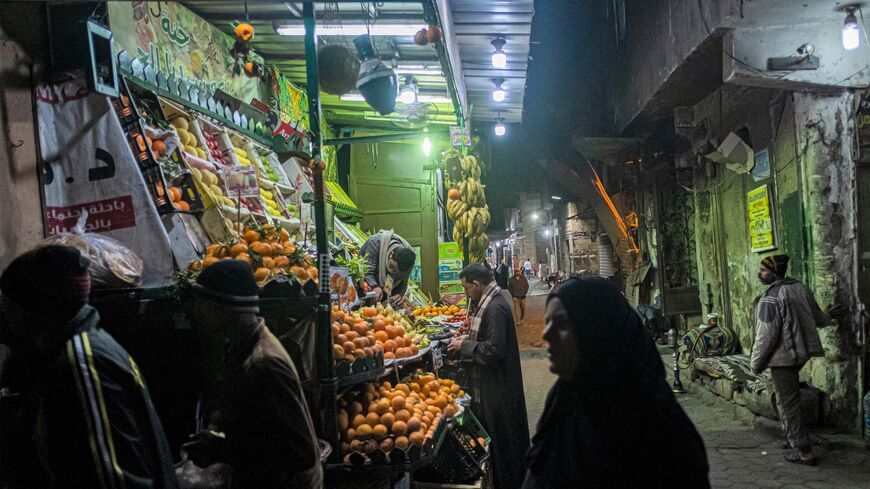 People walk past a fruit seller's stall in the Azhar district of Cairo 