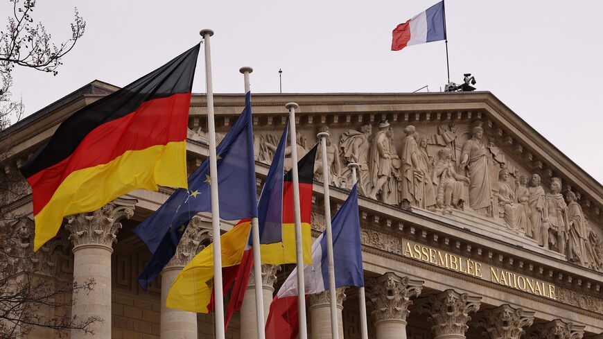 This photograph taken on January 22, 2023 shows German, European Union and French flags and the facade of the French National Assembly. (Photo by THOMAS SAMSON/AFP via Getty Images)