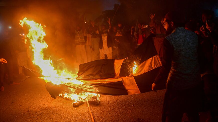 Activists of radical anti-blasphemy party Tehreek-e-Labbaik Pakistan burn a Swedish flag as they protest against the burning of the Koran in Sweden, in Karachi on January 27, 2023. - Several thousand people rallied in Muslim-majority Pakistan after Friday prayers to voice outrage over right-wing protests targeting the Koran in Sweden and the Netherlands. (Photo by ASIF HASSAN/AFP via Getty Images)