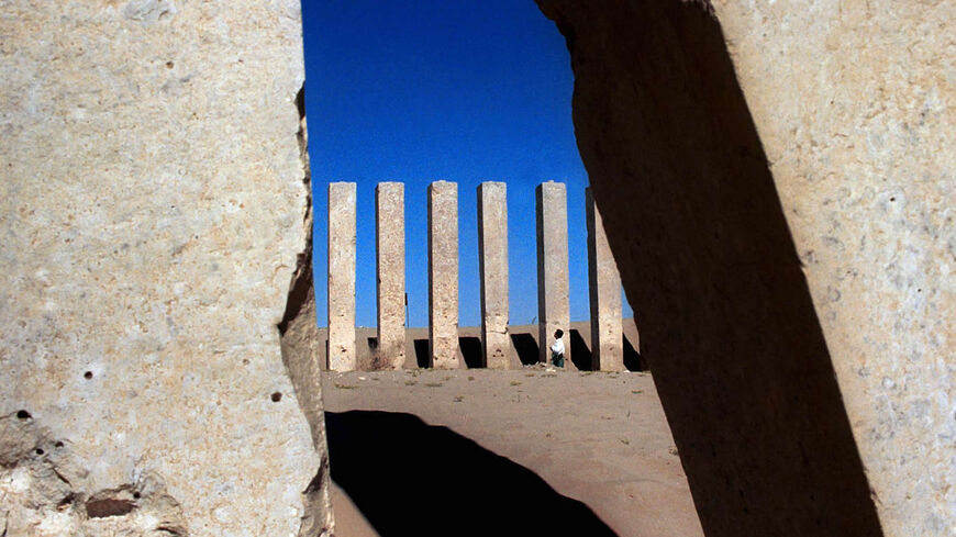 A Yemeni man looks up at pillars at the Awam, or Moon Temple, near the recently restored Arsh, or Throne of Balquis, the site of the legendary kingdom of Sheba, Marib province, Yemen, Dec. 21, 2000.