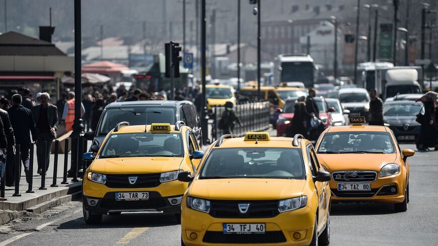Official yellow taxis and van vehicles wait for their customers at the Eminonu district in Istanbul, on March 30, 2018.  (Photo credit OZAN KOSE/AFP via Getty Images)