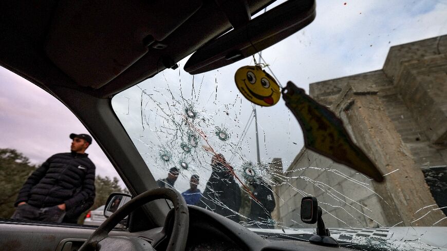 Onlookers surround a bullet-riddled car in which two Palestinians were reportedly killed by Israeli troops in Jaba near the West Bank town of Jenin