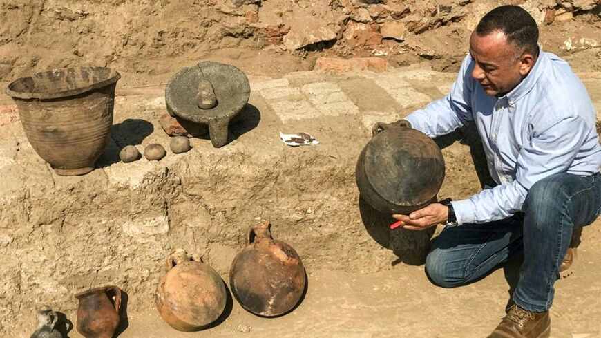 Mostafa Waziri, the head of Egypt's Supreme Council of            Antiquities, inspects a pot discovered at a 1,800-year-old            Roman-era city, as seen in this photograph from the Egyptian            Ministry of Antiquities