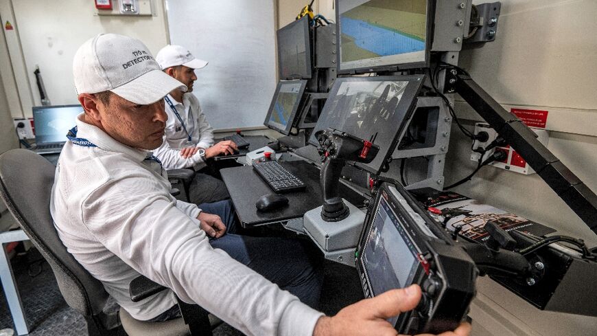 Controllers man a terminal at the command station of the Israel Aerospace Industries in an unmanned maritime demonstration during the Naval Defence and Maritime Security Exhibition (NAVDEX) at the Abu Dhabi International Exhibition Centre 
