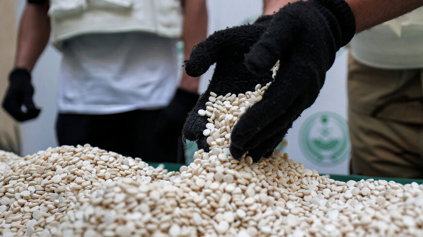 Officers of the Directorate of Narcotics Control of the Interior Ministry sort through tablets of Captagon seized during a special operation and presented before AFP afterward, Jeddah, Saudi Arabia, March 1, 2022.