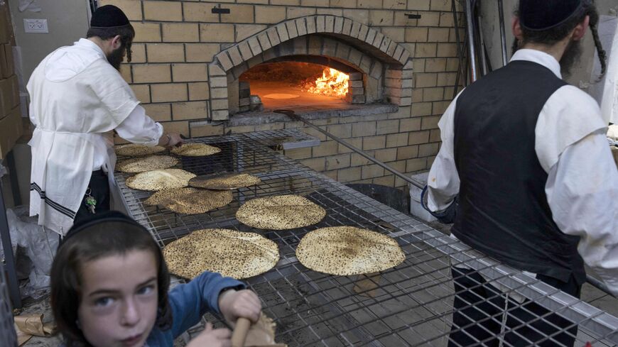 Ultra-Orthodox Jewish men bake Matzoth (unleavened bread) at a bakery in the central Israeli city of Beit Shemesh, on April 11, 2022. Religious Jews eat Matzoth during Pesach holiday (Passover). According to biblical narrative, due to the haste with which the Jews left the land of Egypt, the bread prepared for the journey did not have time to rise. To commemorate their ancestors' plight, religious Jews do not eat leavened food products throughout Passover. MENAHEM KAHANA/AFP via Getty Images)