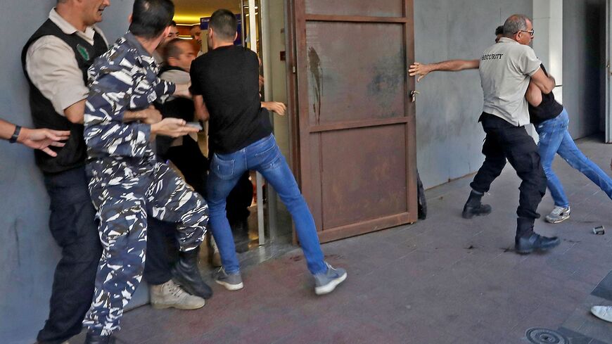 A policeman is stopped by security guards from entering a branch of BLOM Bank in the Lebanese port city of Saida (Sidon) on September 26, 2022 as banks reopened to depositors with scheduled appointments only, following a week of closure due to security concerns. (Photo by MAHMOUD ZAYYAT/AFP via Getty Images)