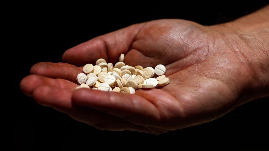 A Lebanese security official holds a handful of confiscated captagon pills in his palm at the judicial police headquarters in the city of Zahle in Lebanon's central Bekaa valley on July 21, 2022. (Photo by JOSEPH EID/AFP via Getty Images)