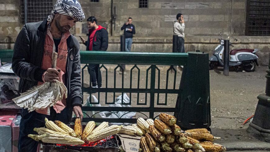 A peddler sells roasted corn cobs by the medieval Sultan al-Ghuri Complex in the Azhar district of Cairo.