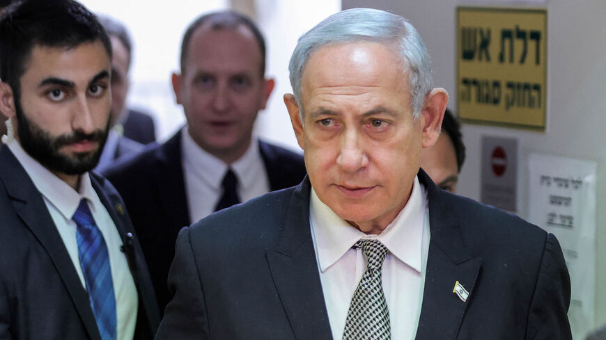Israeli Prime Minister Benjamin Netanyahu (R) walks during a hearing at the Magistrate's Court in Rishon Lezion, Israel, Jan. 23, 2023.