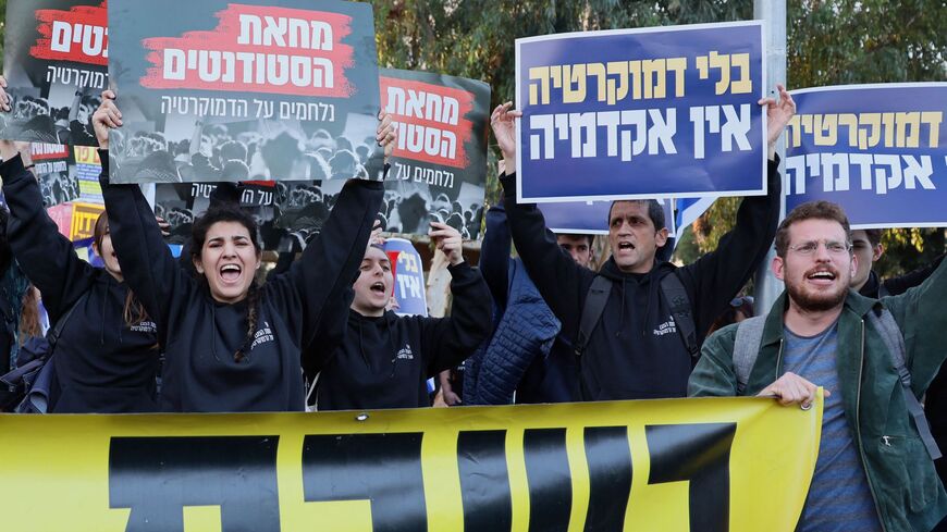Israeli protesters hold placards reading in Hebrew "Israeli students fighting for democracy"(L) and "There is no academy as tool of democracy(R) during a demonstration against controversial government plans to give lawmakers more control of the judicial system, in Tel Aviv on January 26, 2023. - Prime Minister Benjamin Netanyahu and his allies, who have formed the most right-wing government in Israel's history, say the reforms are necessary to correct an imbalance that has given judges too much power over e