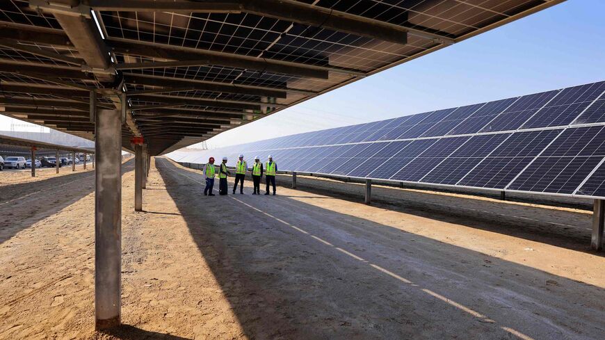 Employees stand at the Al Dhafra Solar Photovoltaic (PV) Independent Power Producer (IPP) project, in the United Arab Emirates' capital Abu Dhabi, during a visit by the French economy minister on January 31, 2023. (Photo by Karim SAHIB / AFP) (Photo by KARIM SAHIB/AFP via Getty Images)