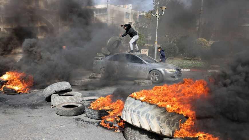 Palestinian protesters burn tyres to block a road leading into Jericho in the occupied West Bank, on February 6, 2023, following a raid in town by Israeli forces.  (Photo by AHMAD GHARABLI/AFP via Getty Images)