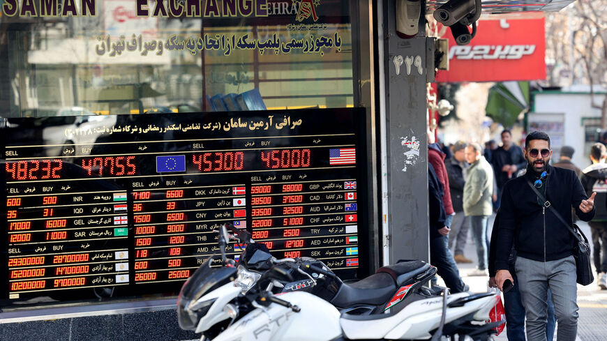 Men look at currency exchange rates at an exchange shop in Tehran on Feb. 21, 2023. Iran's currency plunged to new lows on Jan. 20 amid fresh European Union sanctions, crossing the psychologically important rate of 500,000 rials to a dollar in foreign exchange markets.