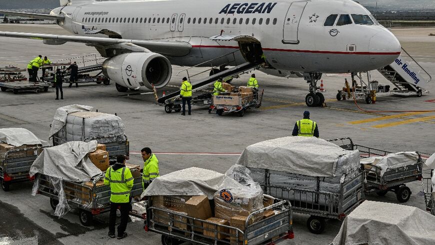 Staff load medical supplies near Athens, as part of Greek aid to Turkey