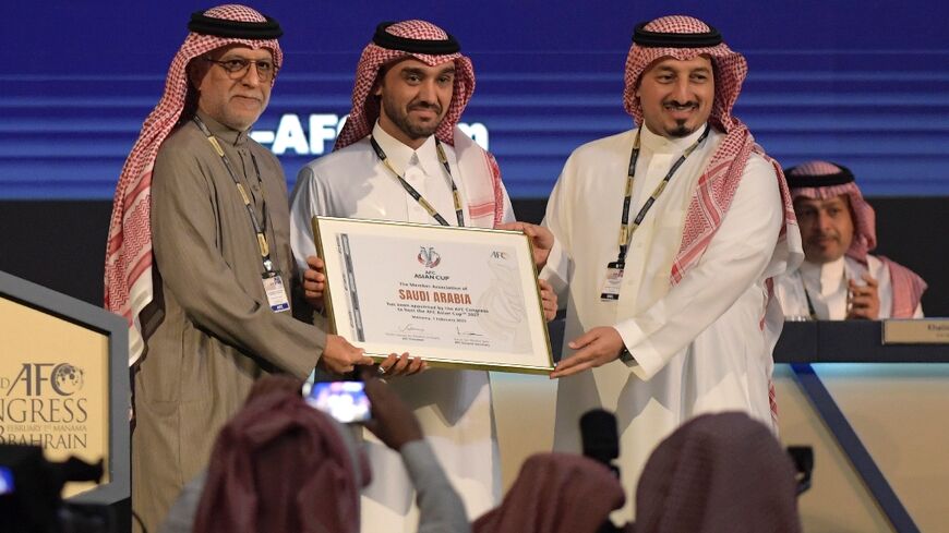 AFC President Salman bin Ibrahim al-Khalifa (L) with Saudi Sports Minister Abdulaziz bin Turki al-Faisal al-Saud (C) as Saudi Arabia was awarded the 2027 Asian Cup