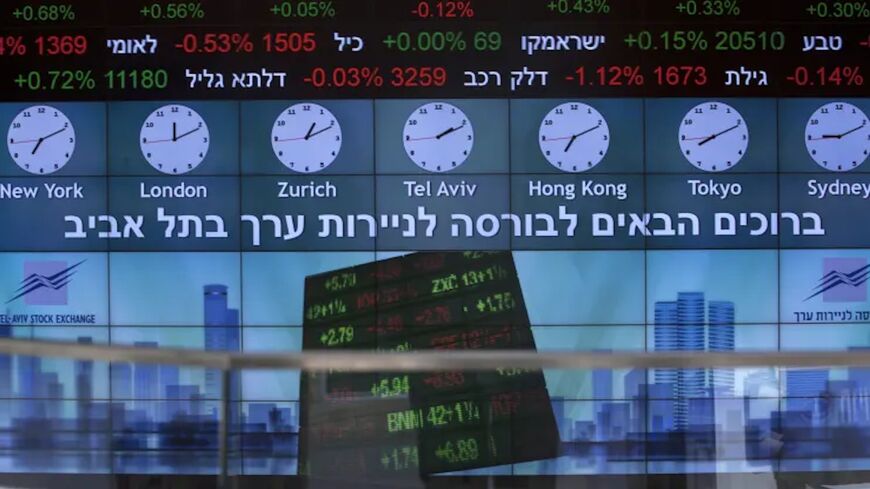 A stock market ticker displays financial information and world time zones in the lobby of the Tel Aviv Stock Exchange.
