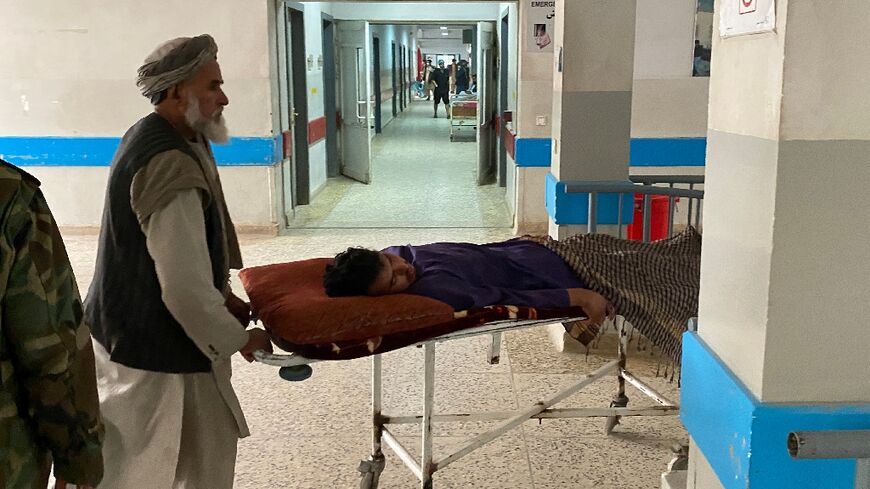 Men move a wounded man inside a hospital in Mazar-i-Sharif, after a suicide attack at the office of the Taliban governor of Afghanistan's Balkh province
