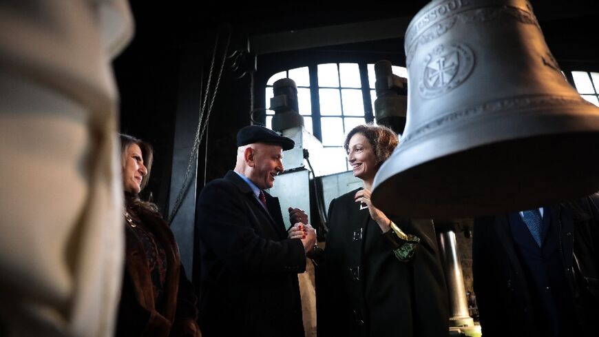UNESCO Director-General Audrey Azoulay (C) shakes hands with Iraqi ambassador to France Wadee al-Batti on December 5, 2022 at the enveiling of a bell for Mosul's Our Lady of the Hour convent