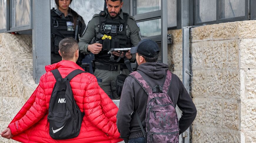 Palestinian youths present themselves to Israeli border guards during a search at the Damascus Gate of the Old City of Jerusalem, on February 23, 2023