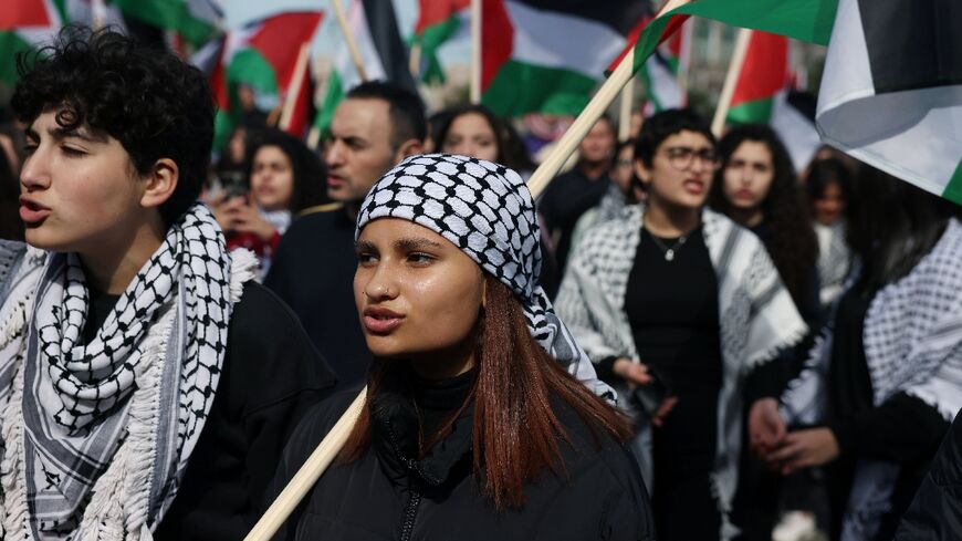 Protesters in Sakhnin wave Palestinian flags and wear the traditional keffiyeh scarf during a march on the 47th Land Day