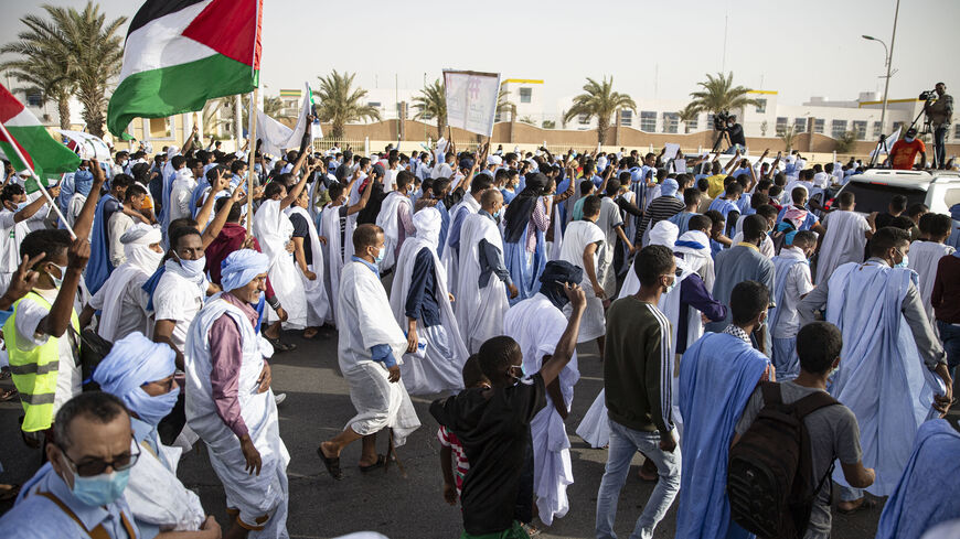 Protesters carry the Palestinian National Flag during a march in support of the Palestinian people in Nouakchott, Mauritania on May 19, 2021. (Photo by MED LEMIN RAJEL/AFP via Getty Images)