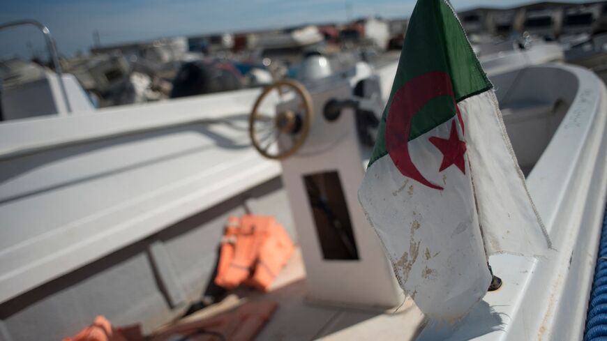 An Algerian flag is displayed on a small boat used by migrants to cross The Alboran Sea, in an open-air warehouse in Almeria, southeast Spain, on October 15, 2021. - At least 309 migrants, 13 of them minors, have died in the western Mediterranean since the start of the year, figures from the International Organization for Migration (IOM) show. The number of Algerians arriving on the coast of southeastern Spain or the Balearic Isles has soared in recent months. A confidential document compiled by the Spanish