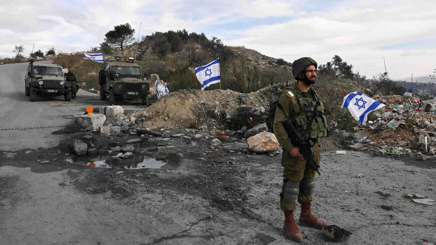 Israeli soldiers guard the road leading to the Homesh yeshiva, located at the former settlement of Homesh, west of Nablus, West Bank, Dec. 30, 2021.