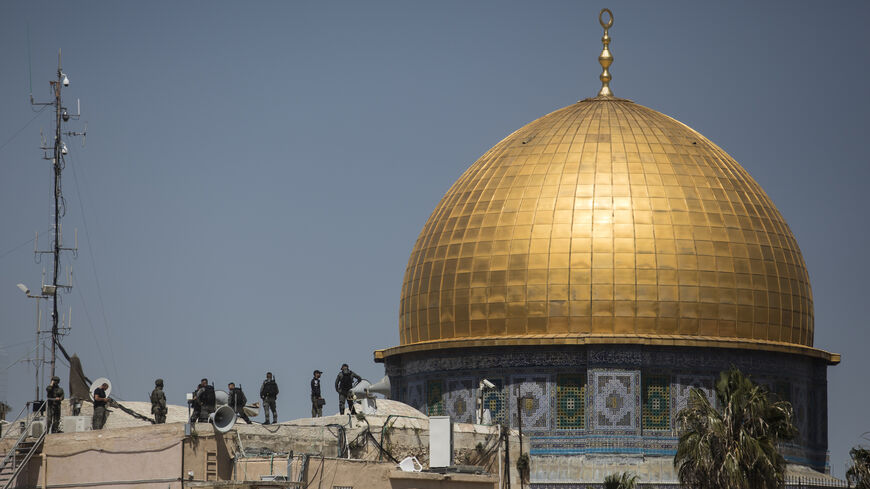 Israeli police officers stand on a rooftop near Al-Aqsa Mosque.