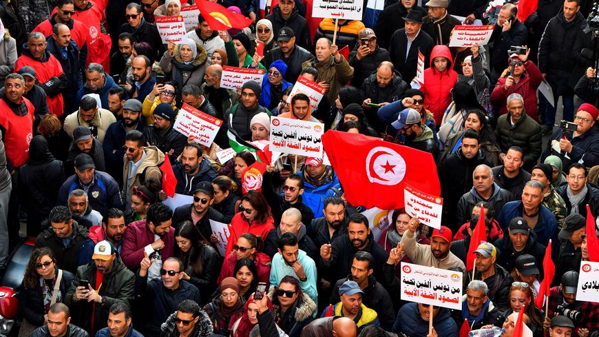 Demonstrators lift placards and national flags during an anti-government rally called for by the powerful trades union federation UGTT in Tunis, on March 4, 2023. (Photo by FETHI BELAID / AFP) (Photo by FETHI BELAID/AFP via Getty Images)
