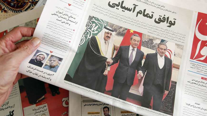 A man in Tehran holds a local newspaper reporting on its front page the China-brokered deal between Iran and Saudi Arabia to restore ties, signed in Beijing the previous day, March 11, 2023.
