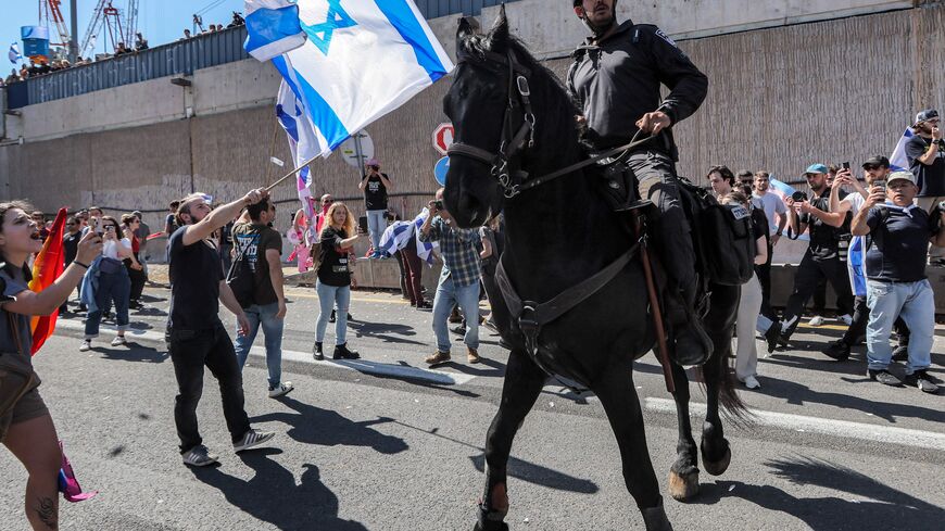 Demonstrators confront Israeli mounted policemen during a rally against the government's controversial judicial overhaul bill in Tel Aviv on March 16, 2023. (Photo by JACK GUEZ / AFP) (Photo by JACK GUEZ/AFP via Getty Images)