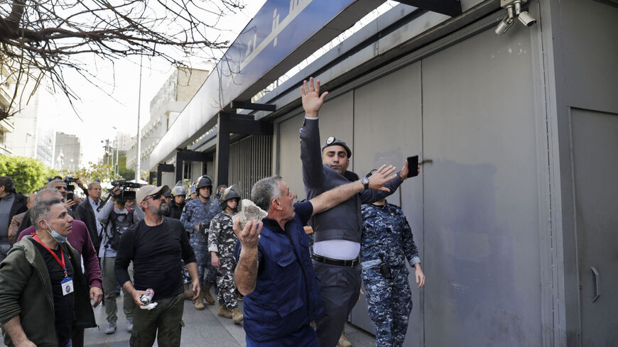 Lebanese forces try to prevent protestors from vandalising a private bank during a demonstration by members of the banks depositors committee against monetary policies, on March 24, 2023. - Lebanon's economic meltdown, described by the World Bank as one of the worst in recent global history, has plunged most of the population into poverty according to the United Nations. (Photo by ANWAR AMRO / AFP) (Photo by ANWAR AMRO/AFP via Getty Images)
